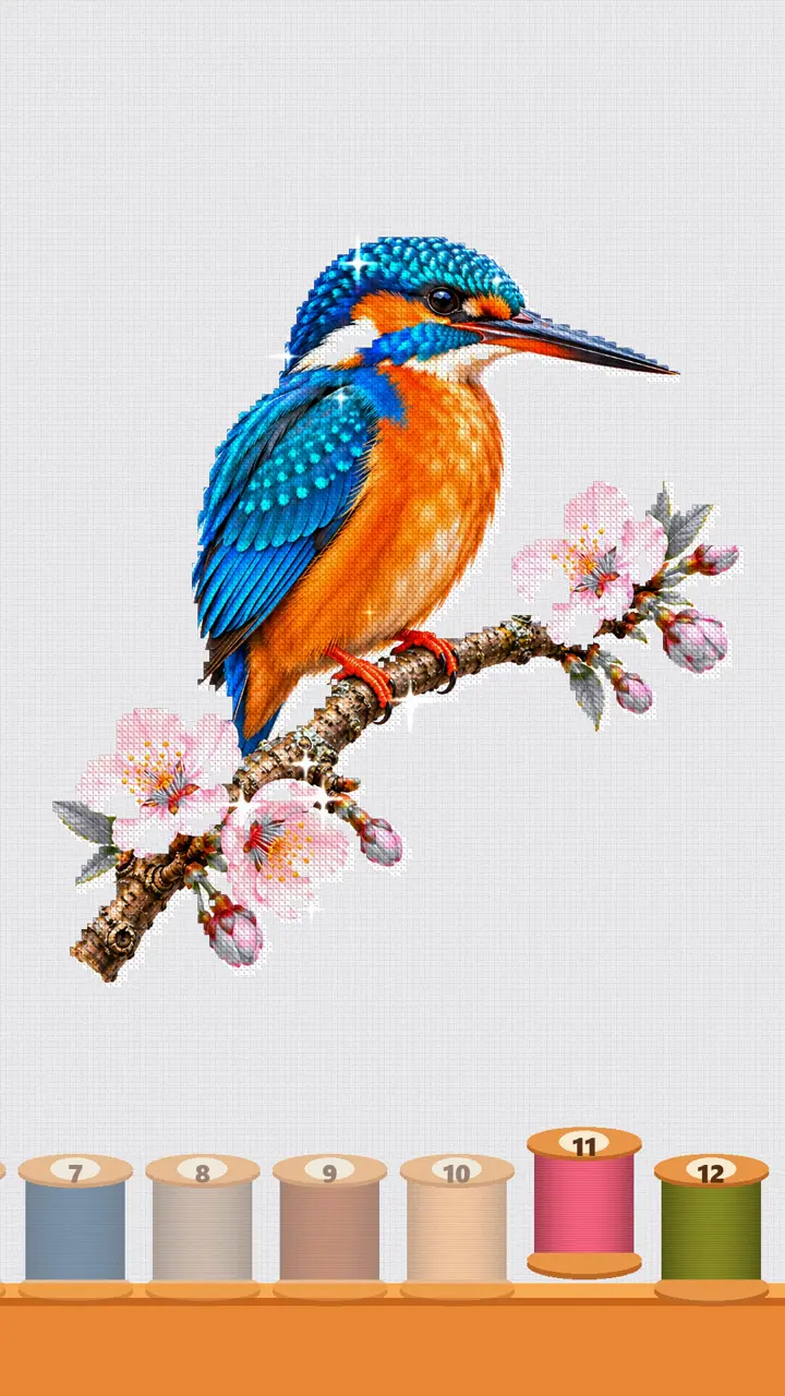 A kingfisher on a cherry blossom branch, stitched in cross stitch